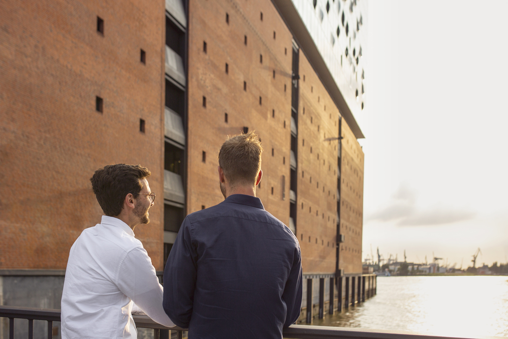 Men looking at Elbphilharmonie Geschäftsleute blicken auf die Elbphilharmonie in der Hamburger Speicherstadt