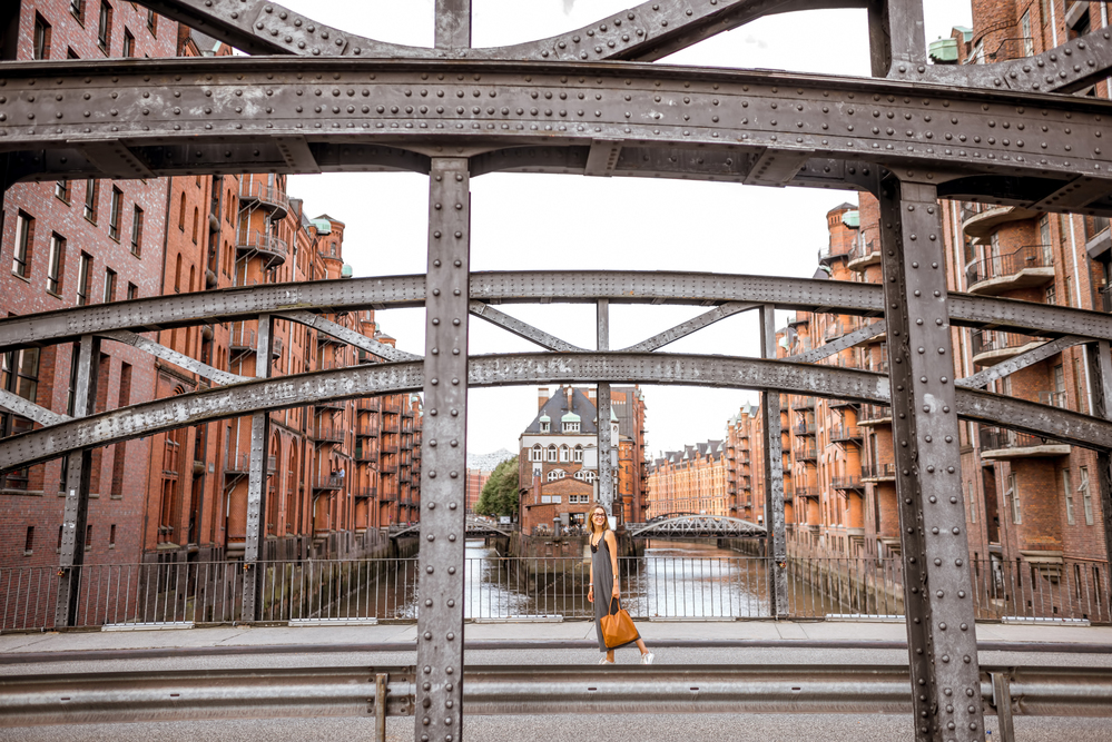 Business woman on the iron bridge Eiserne Brücke mit Frau zu Fuß in der Speicherstadt, historisches Lagerhausviertel in Hamburg, Deutschland