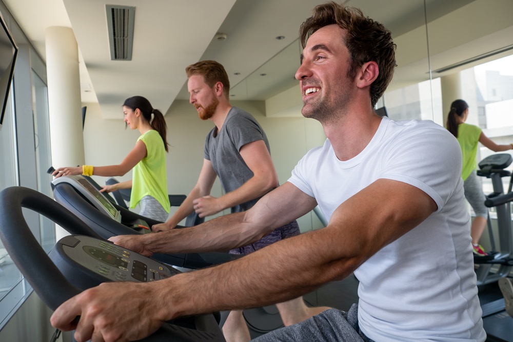 Group of young friends doing exercises in gym gym hotel services