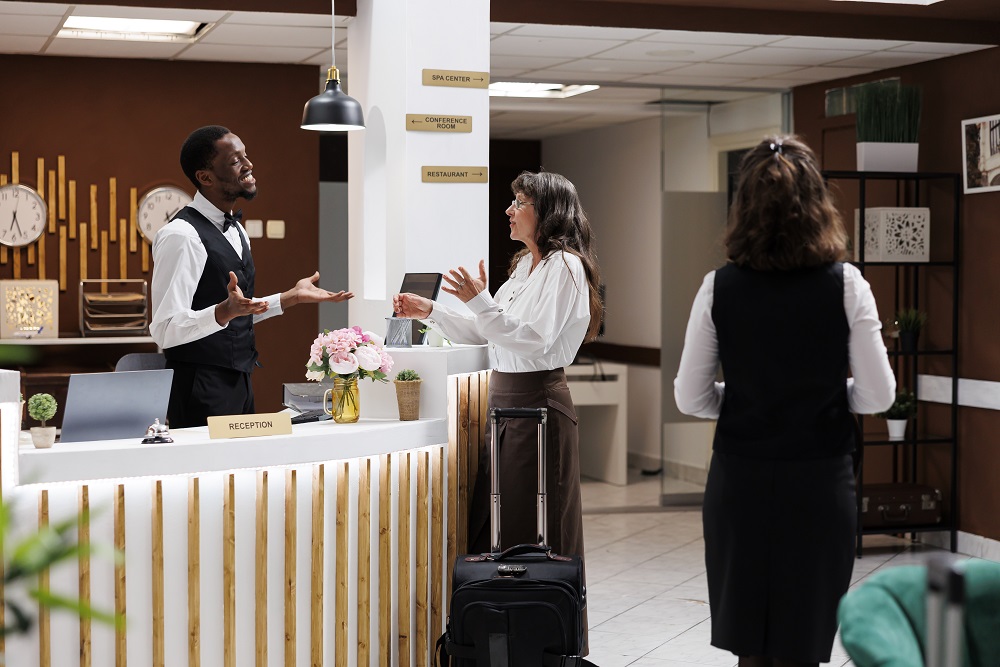 Warmly welcoming hotel reception business traveler checking in to hotel in Boston