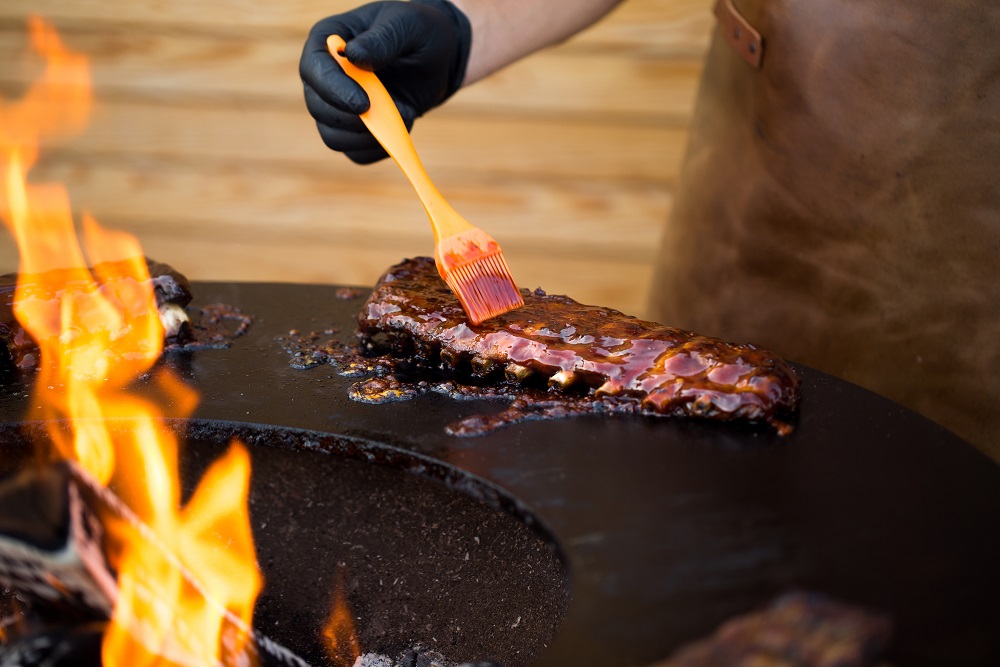 Grilled pork baby ribs with barbecue sauce on the grill. Festival street food. Austin barbacue