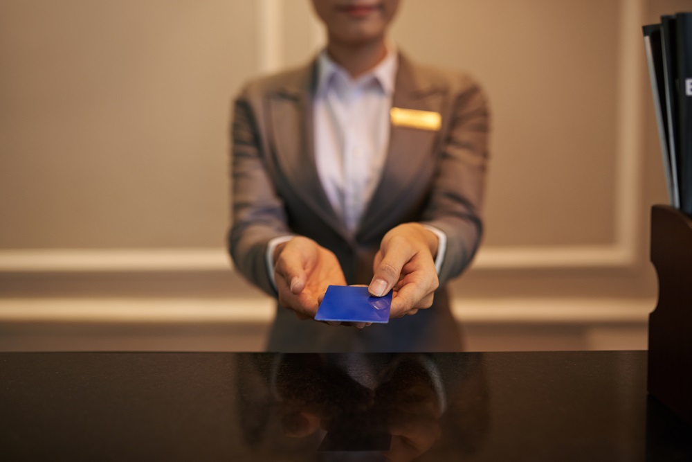 Smart card Hotel receptionist with hotel loyalty card in hands